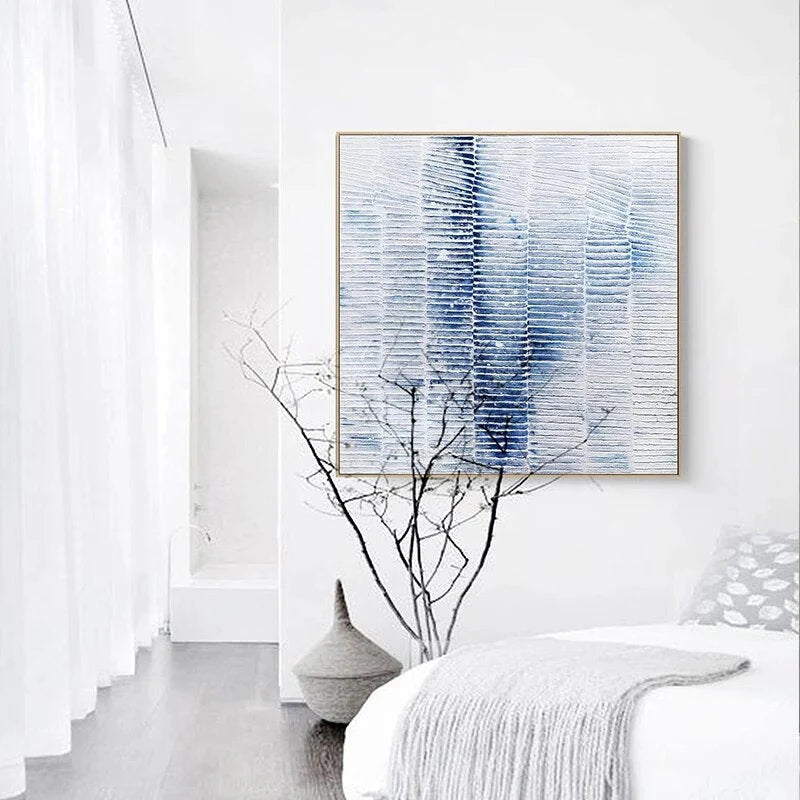 Abstract blue and white painting on a wall with minimal decor