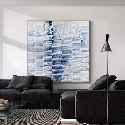 Modern living room with a black sofa, abstract painting, and floor lamp.