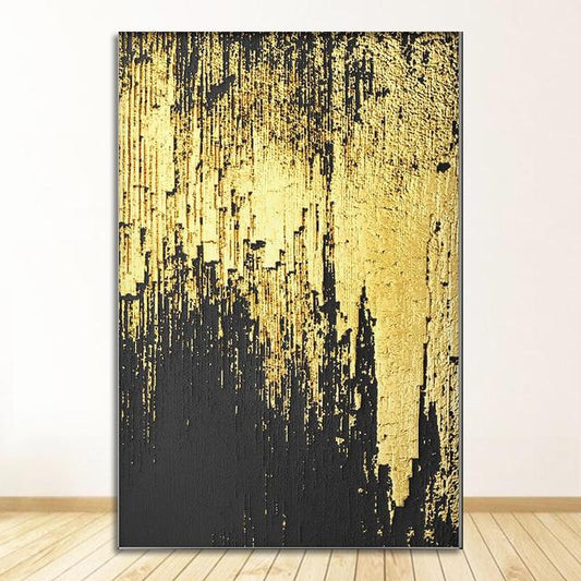 Abstract art piece with black and gold brushstrokes on a white wall.