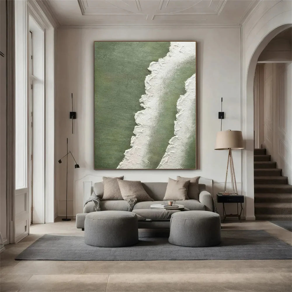 Modern living room with gray sofa, ottomans, and a large abstract painting on the wall.