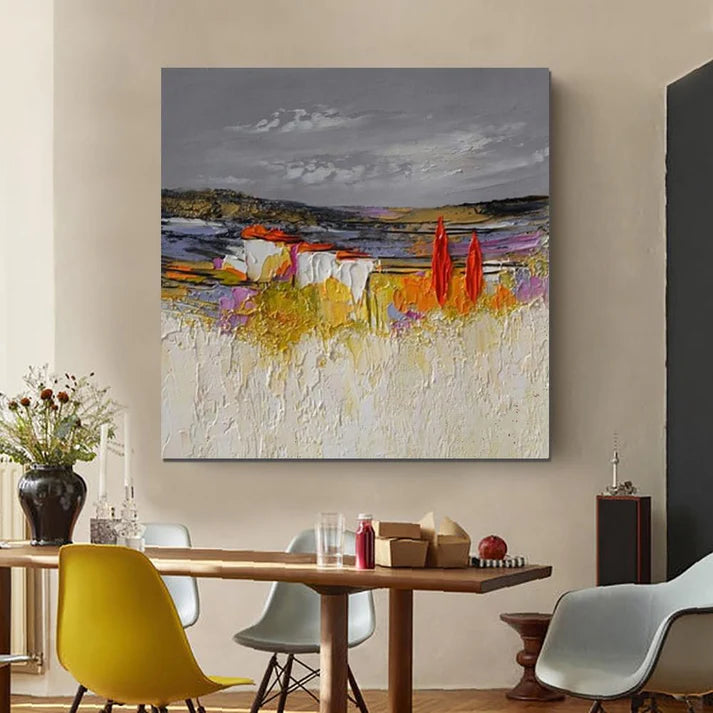 Abstract painting on a wall above a dining table with chairs.