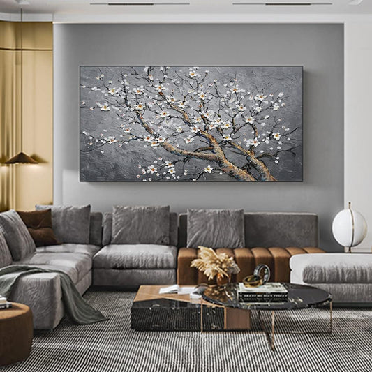 Living room with a large wall art piece of a floral branch on a gray background.