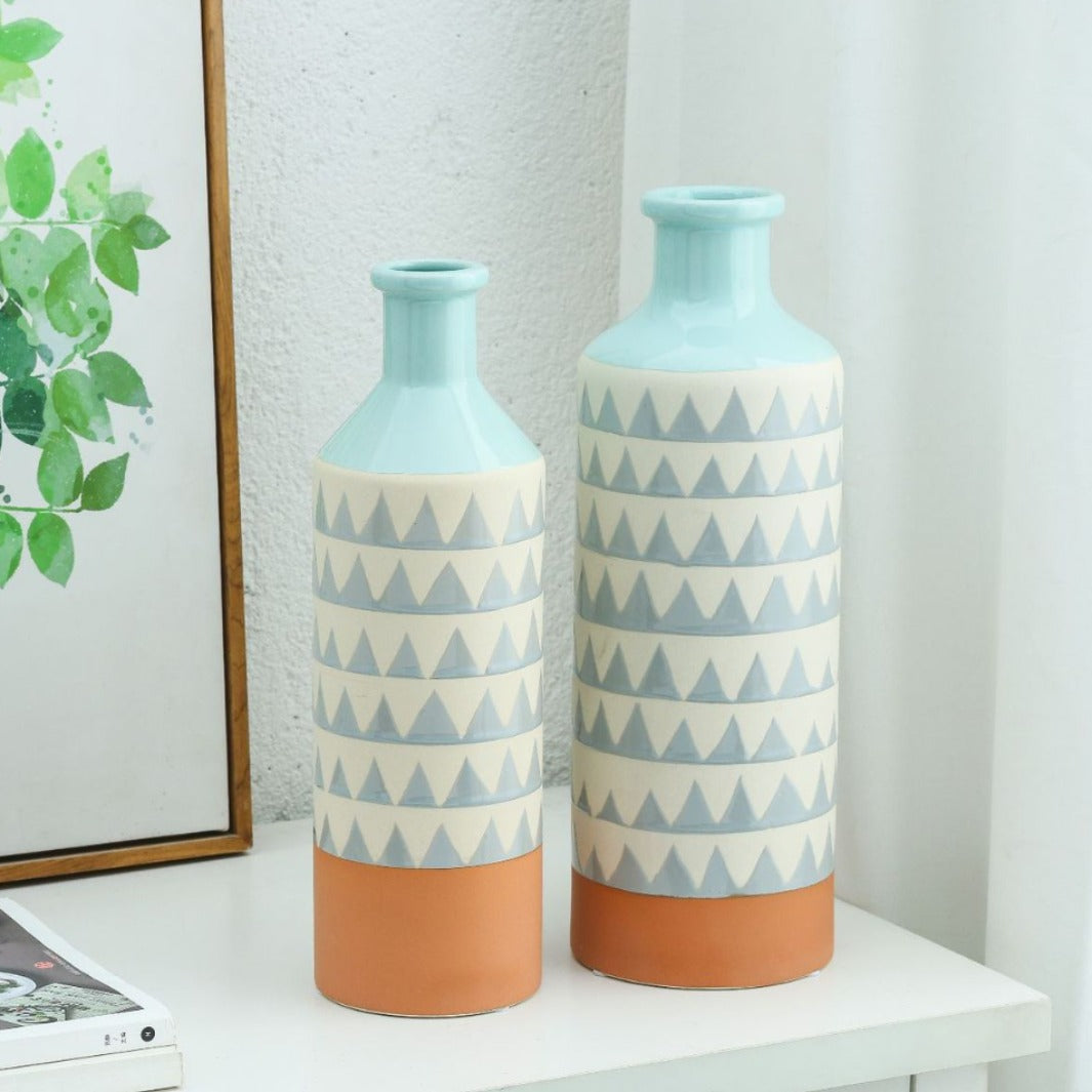 Two decorative vases with geometric patterns on a white surface.