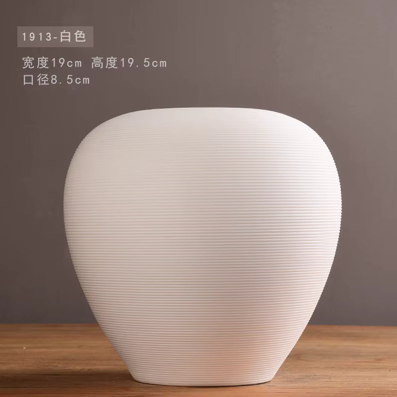 White textured vase on a wooden surface with a dark background