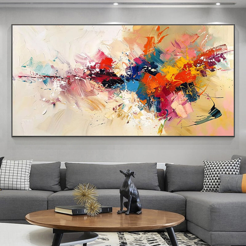 Colorful abstract painting on a gray wall above a gray sofa with decorative items.