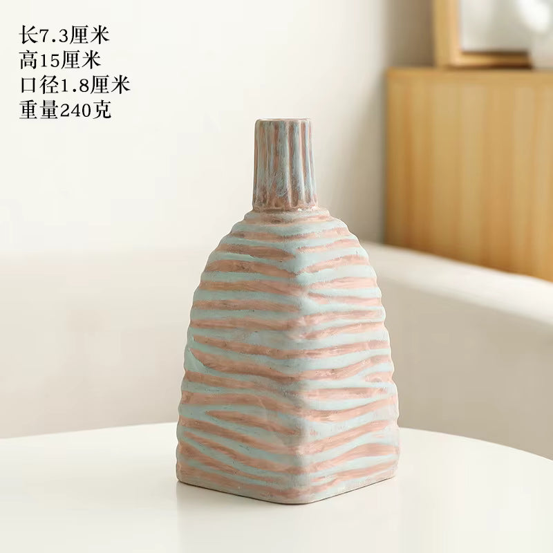 Decorative vase with wavy pattern on a white surface