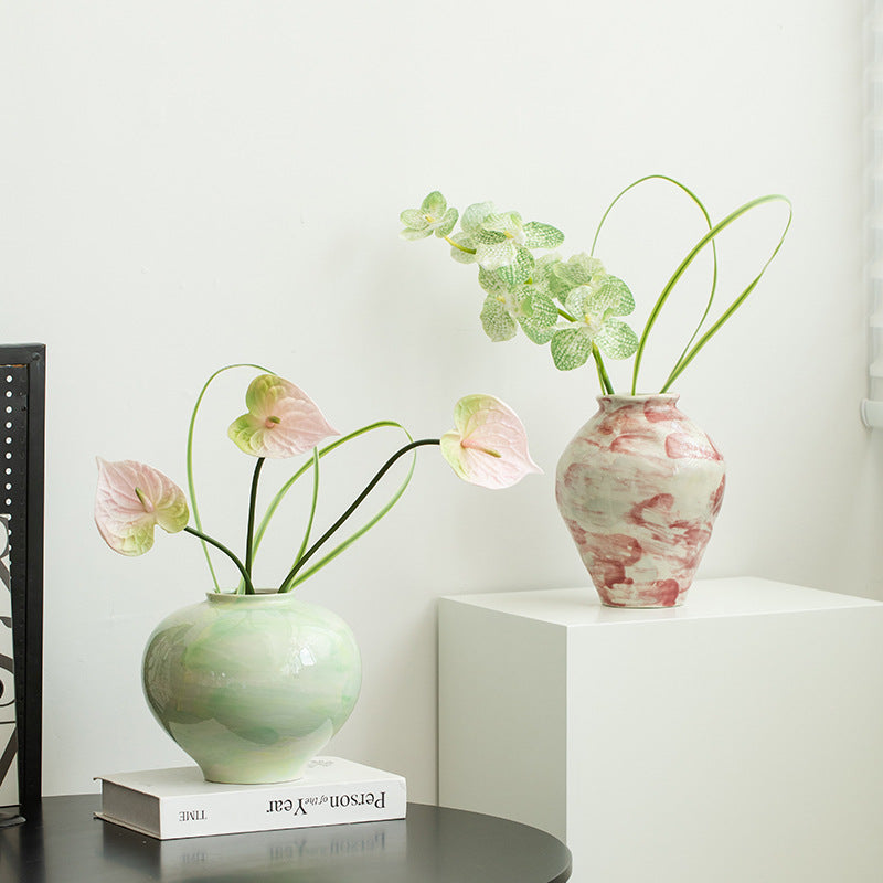 Two vases with flowers on a white surface