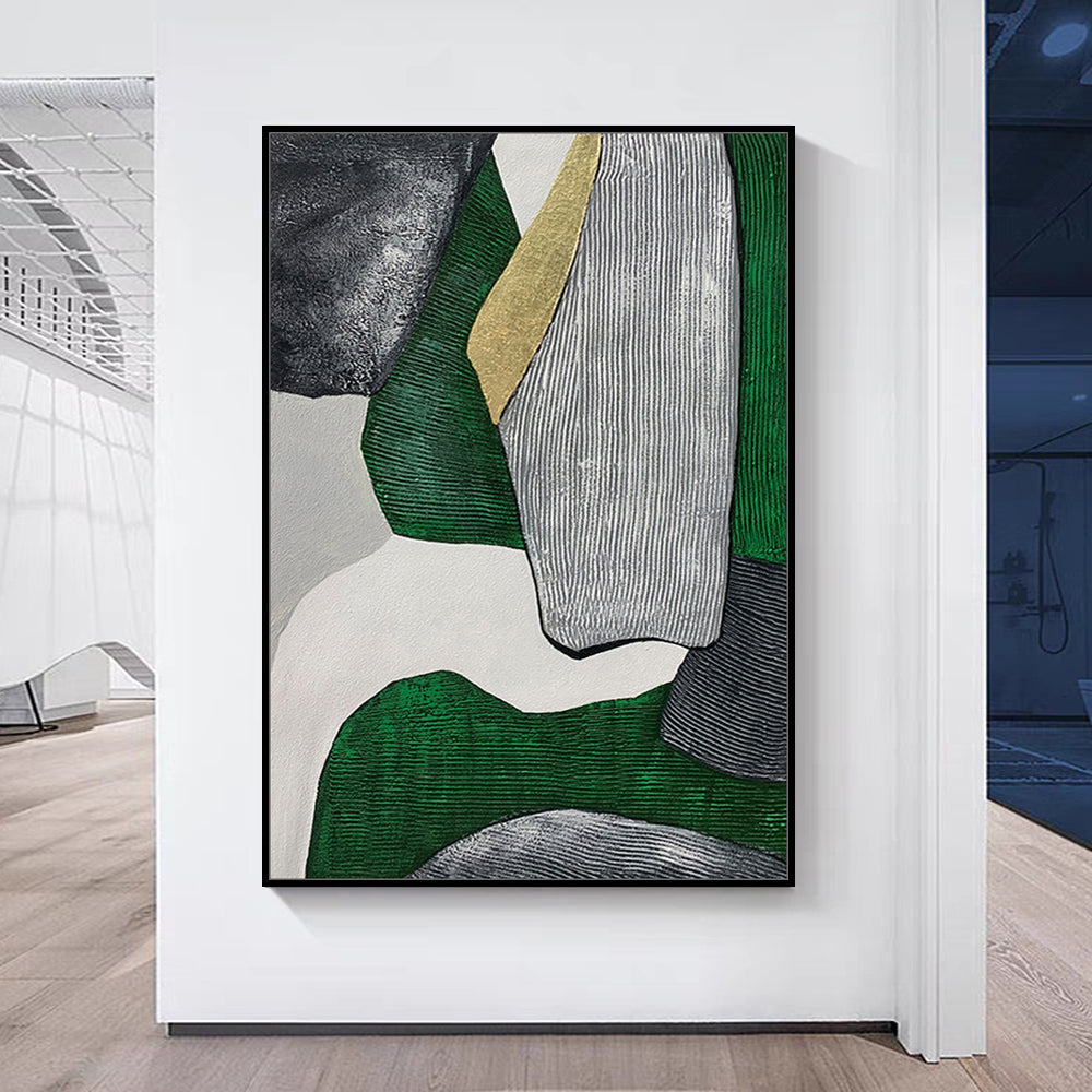 Abstract art piece with green, gray, and gold colors on a white wall.