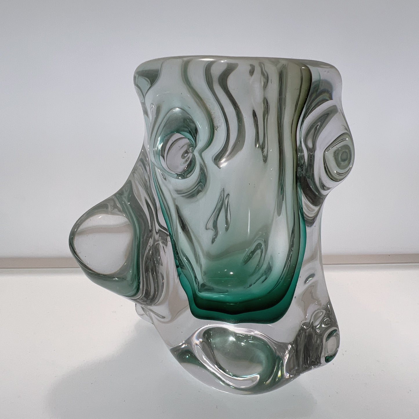 Glass sculpture with wavy design on a white background