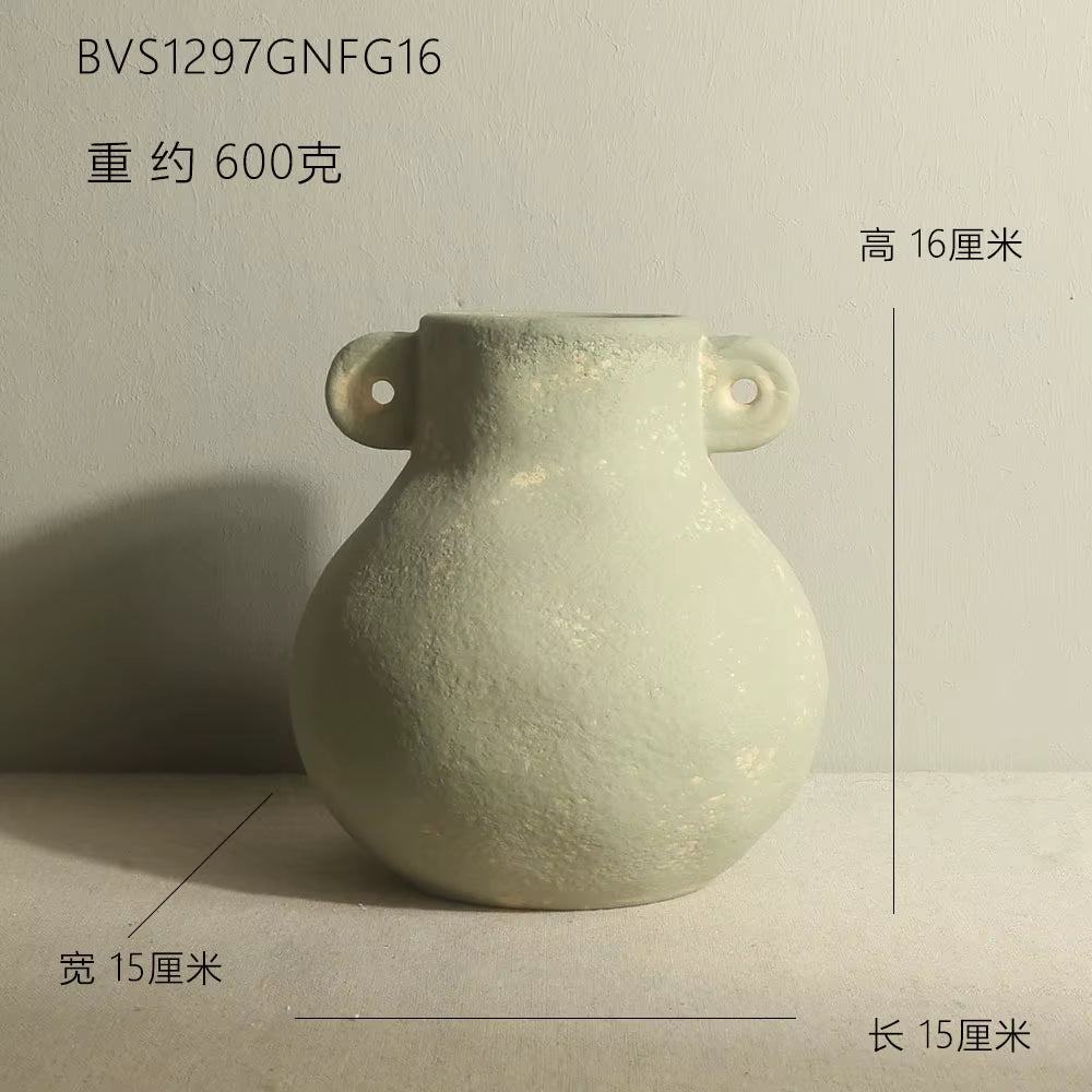 Light green ceramic vase with handles on a gray background
