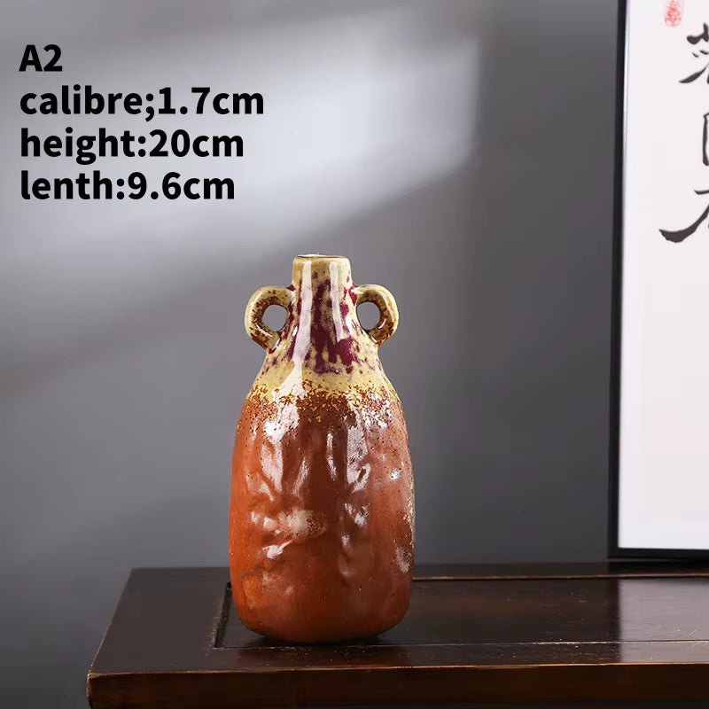 Small ceramic vase with handles on a wooden surface against a gray background