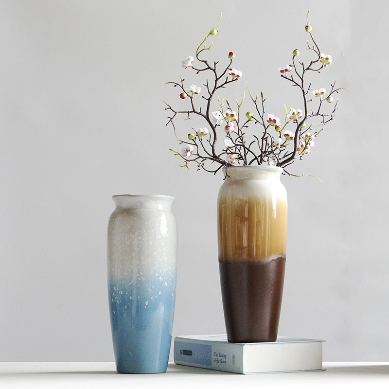 Two vases with gradient colors and a decorative branch on a light gray background