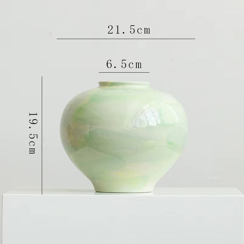 Green ceramic vase with measurements on a white background