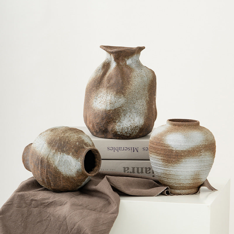 Three ceramic vases on a light surface with a neutral background