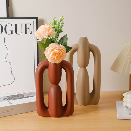 Decorative vases with floral arrangement on a wooden surface