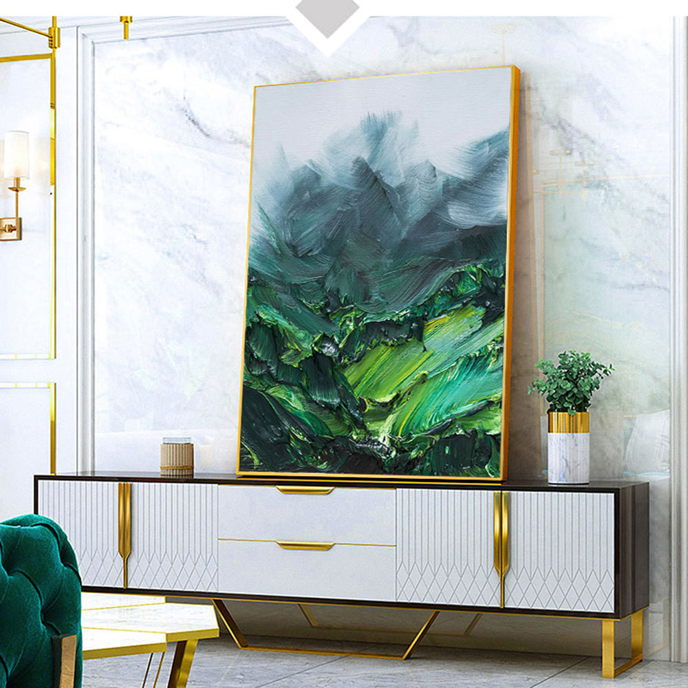 Modern interior with a large abstract green painting on a white wall, a black and gold sideboard, and a green armchair.