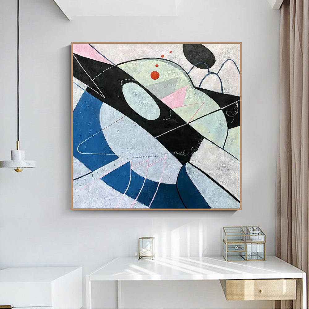 Abstract art piece on a wall above a white desk