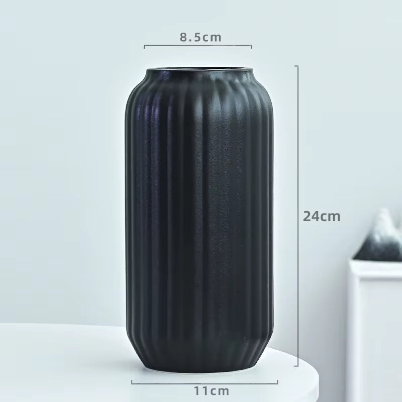 Black ribbed vase with dimensions on a light gray background