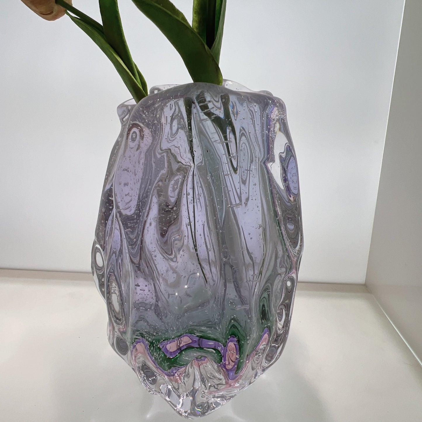 Decorative glass vase with marbled design on a white surface