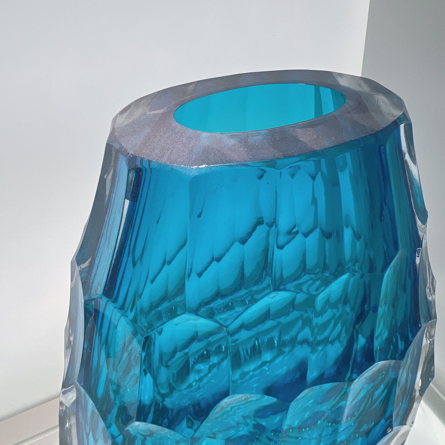 Blue glass vase with textured surface on a white background