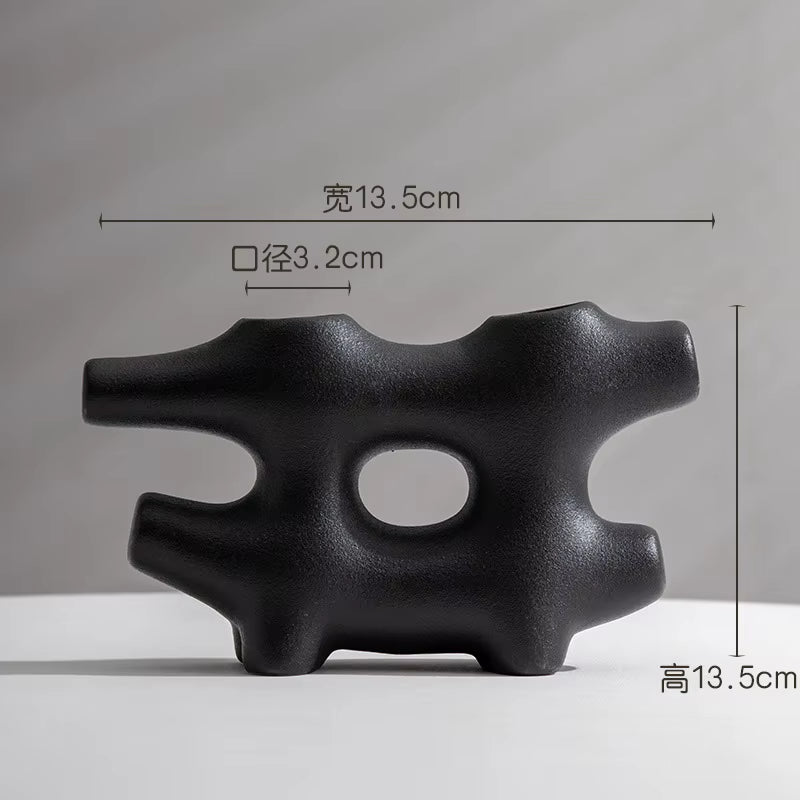 Black abstract sculpture with measurements on a gray background