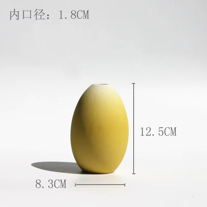 Yellow ceramic egg-shaped object with measurements on a white background