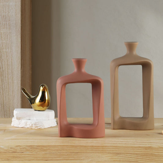 Two ceramic vases on a wooden surface with a neutral background