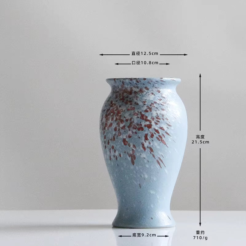 Blue ceramic vase with red speckles and measurements on a white background