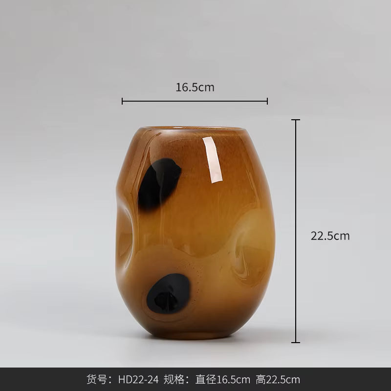 Brown glass vase with black spots and measurements on a gray background
