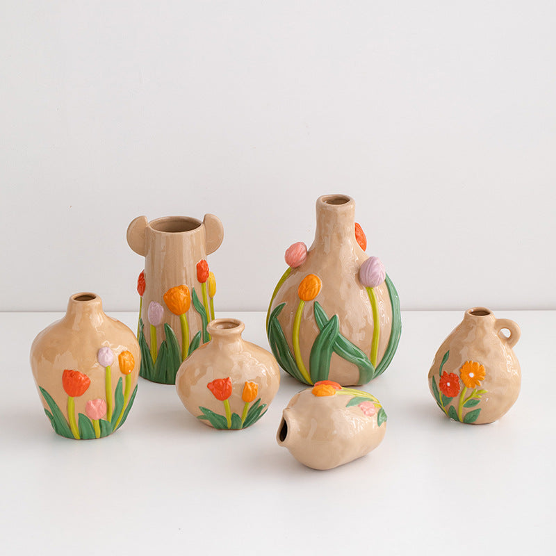 Set of small ceramic vases with floral designs on a white background