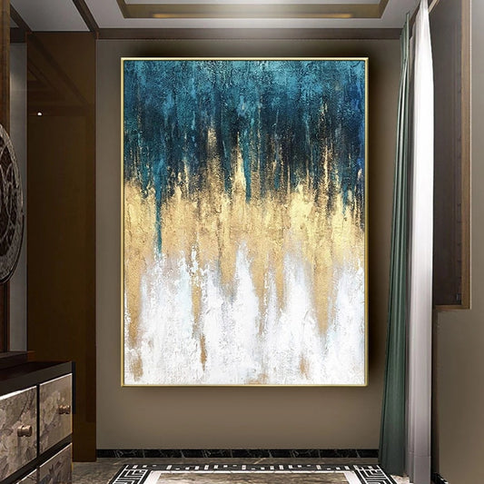 Abstract painting with blue, gold, and white colors on a wall in a room.