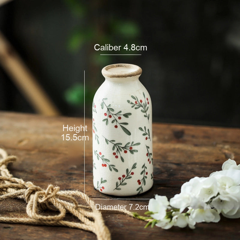 Ceramic vase with floral design on a wooden surface with measurements displayed.