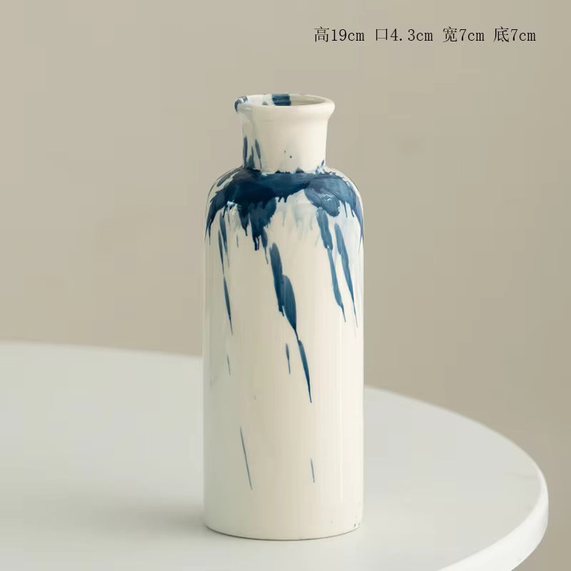 Cylindrical vase with blue abstract patterns on a beige background