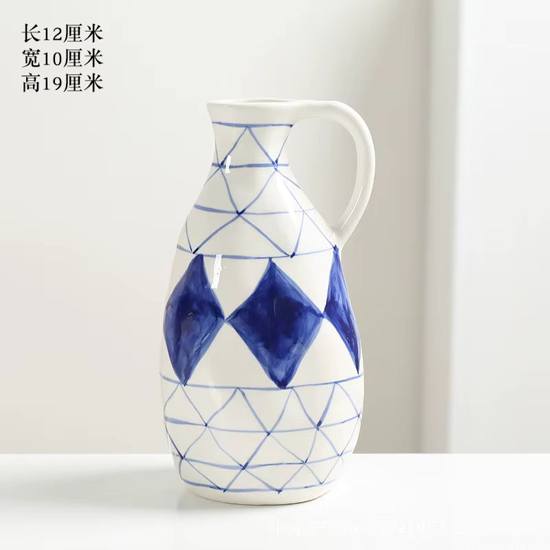 Ceramic pitcher with blue geometric patterns on a white background