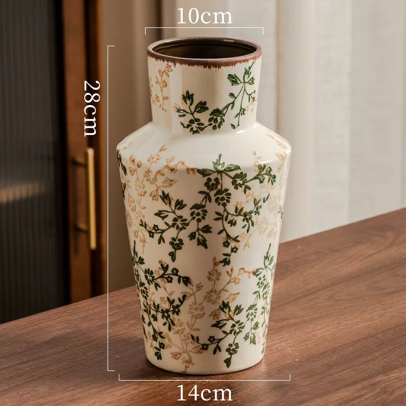 Decorative vase with floral patterns on a wooden surface, with measurements indicated.