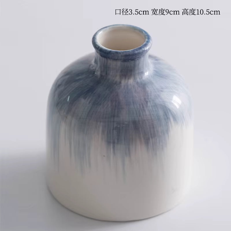 Cylindrical ceramic vase with blue gradient design on a white background