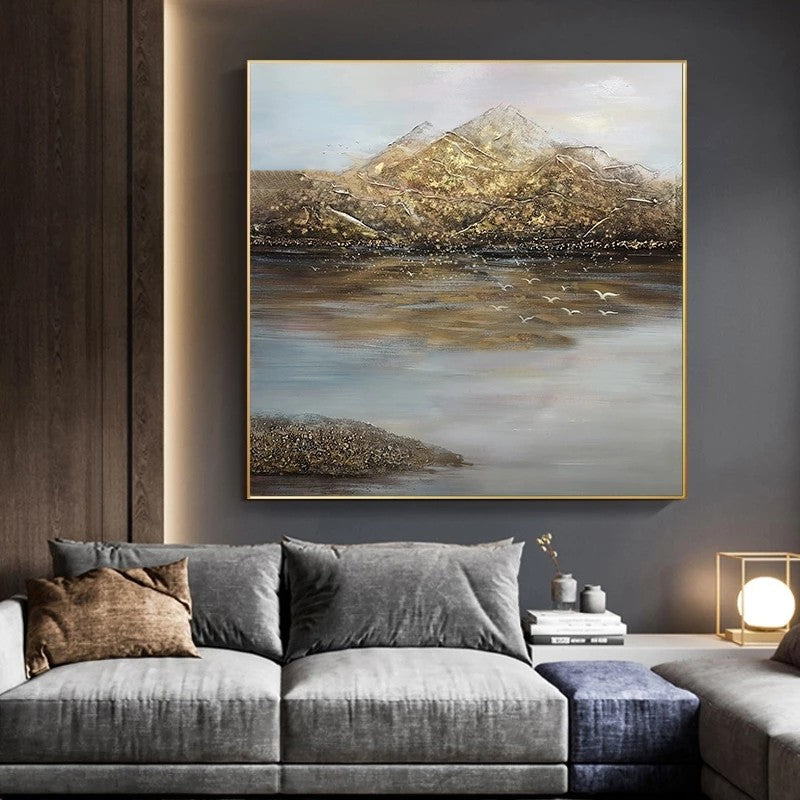 Modern living room with a gray sofa, decorative pillows, and a large landscape painting on the wall.