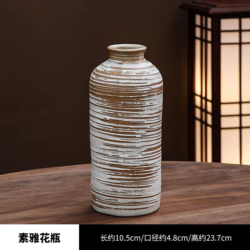 Decorative ceramic vase on a wooden surface with a warm light in the background