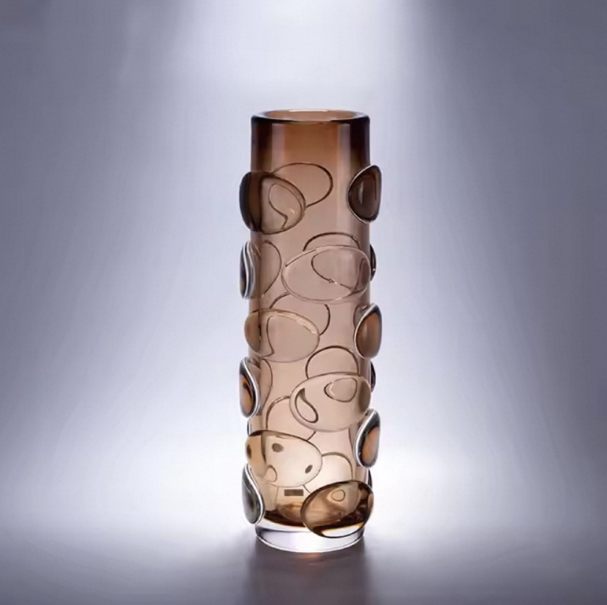 Decorative glass vase with circular patterns on a gray background