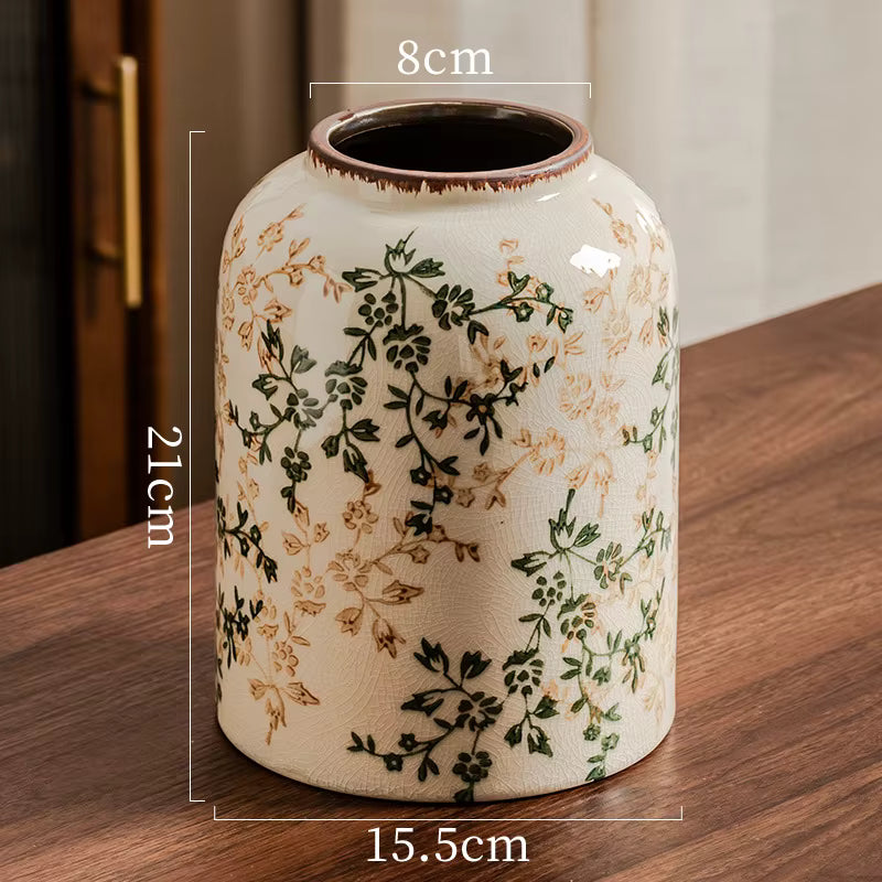 Ceramic vase with floral patterns on a wooden surface, showing dimensions.