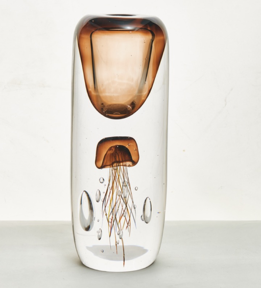Glass vase with a jellyfish inside on a white background