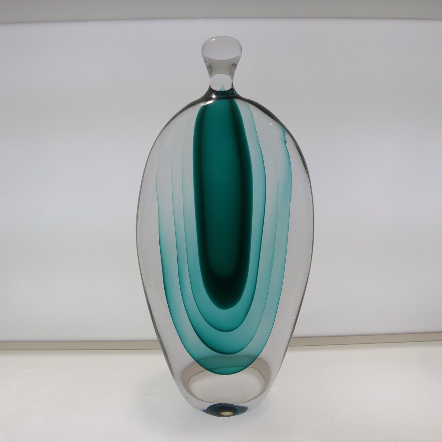 Decorative glass vase with teal and clear design on a white background