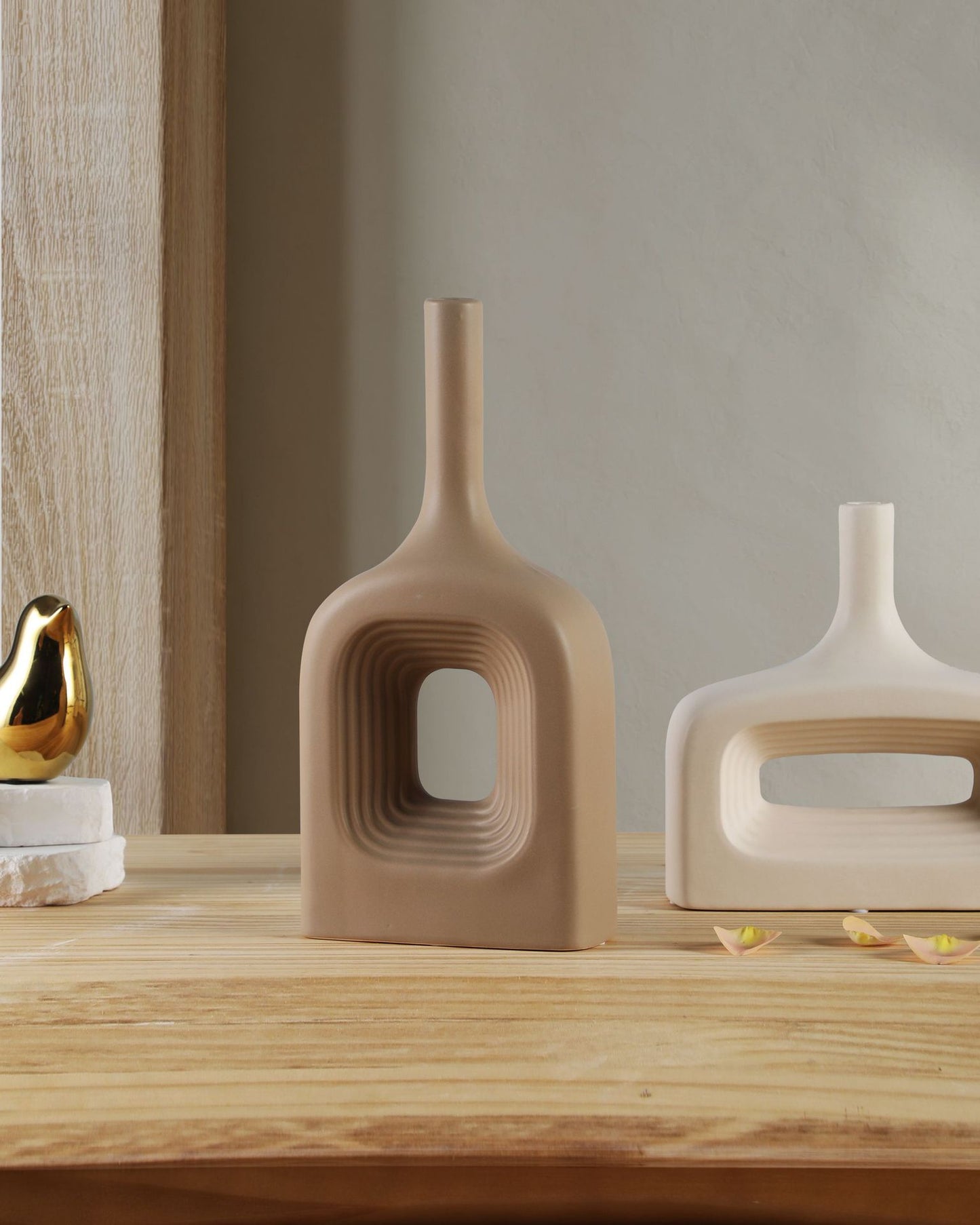 Decorative vases on a wooden surface with a neutral background