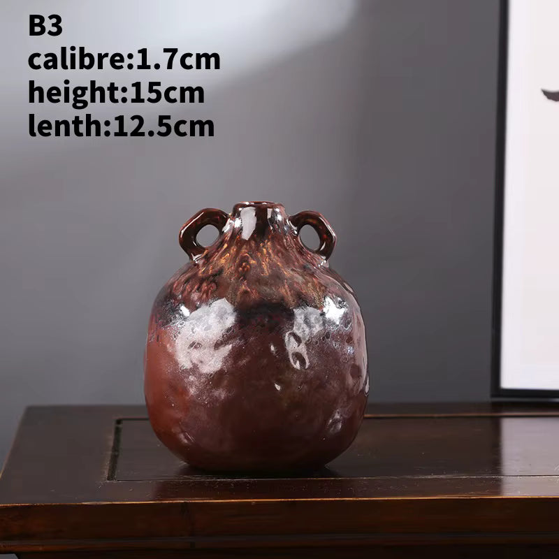 Decorative vase with handles on a wooden surface against a gray wall