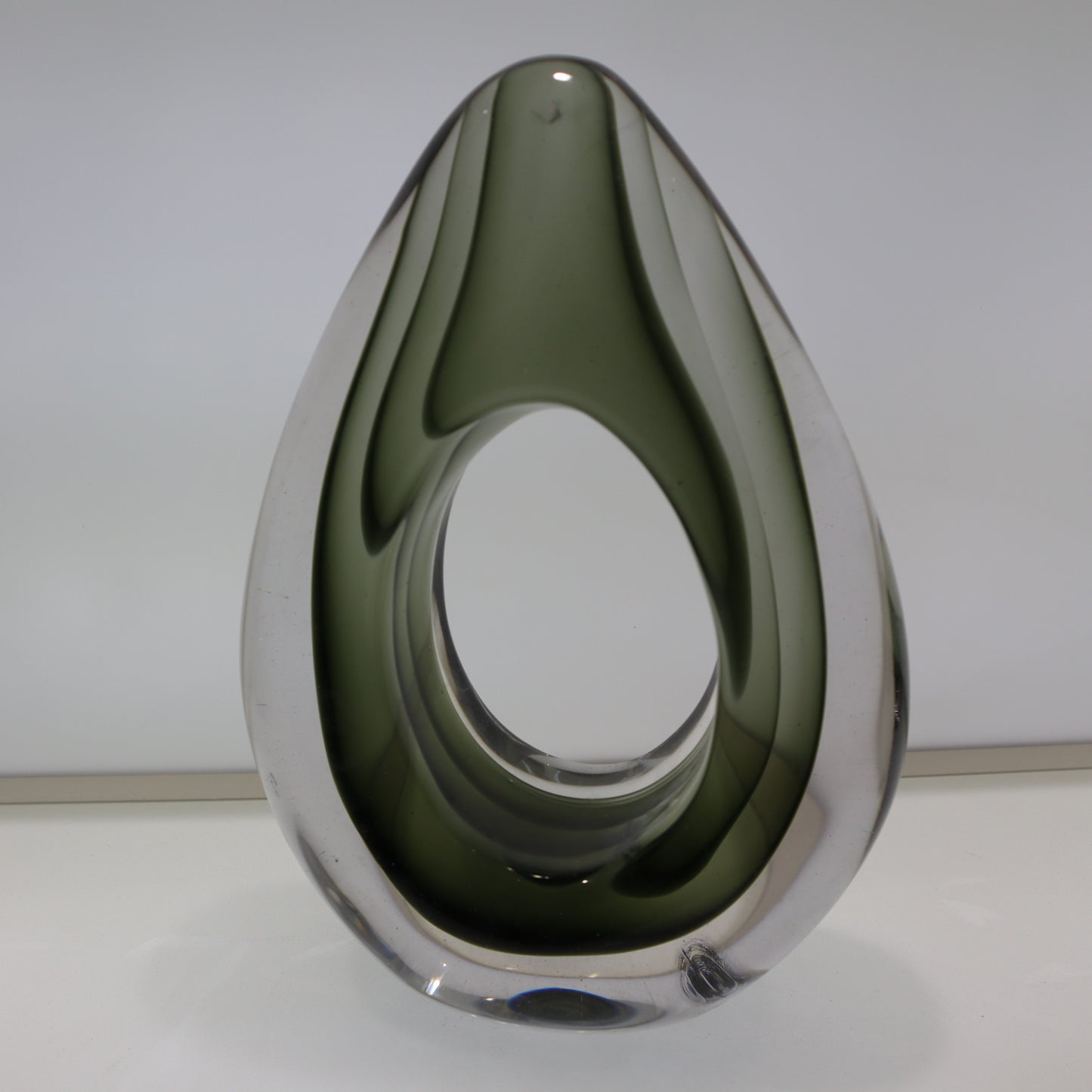 Teardrop-shaped object with reflective surface on a white background