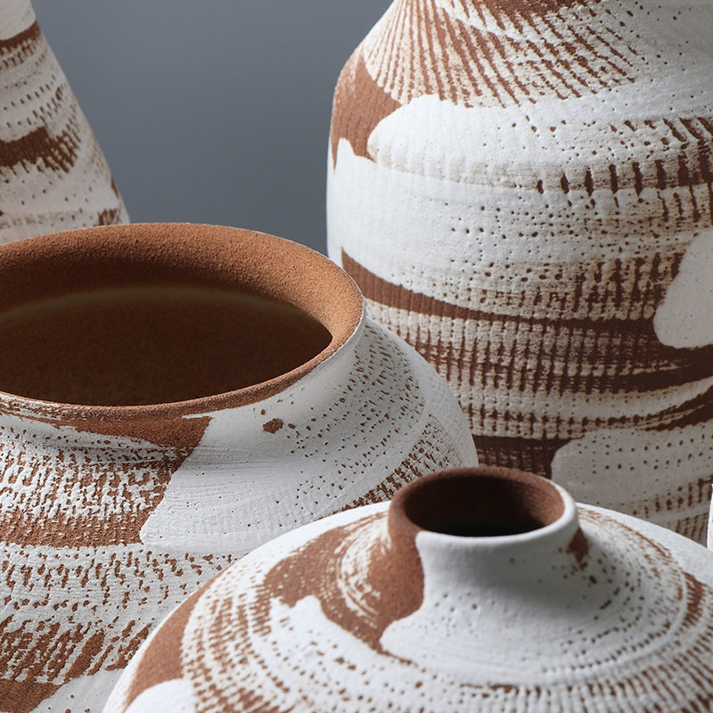 Close-up of ceramic pots with textured brown and white design on a gray background