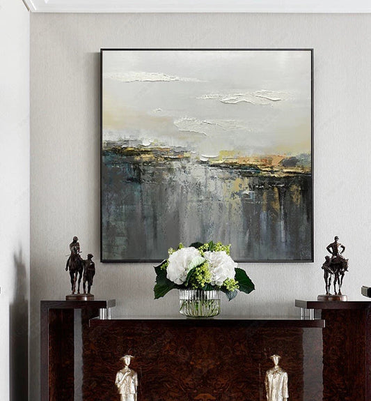 Abstract painting on a wall above a console table with decorative items.