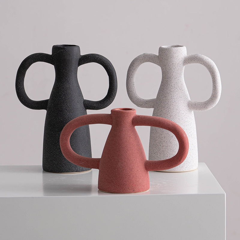 Three ceramic vases in black, red, and white on a light gray background