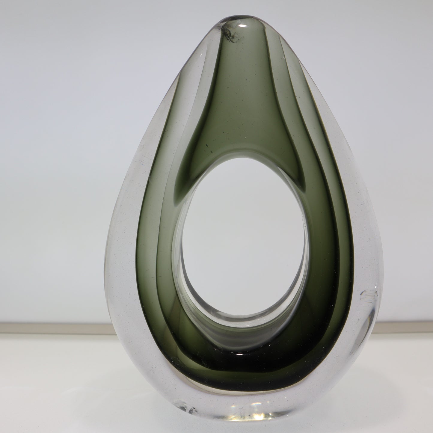 Modern glass vase with a teardrop shape on a white background