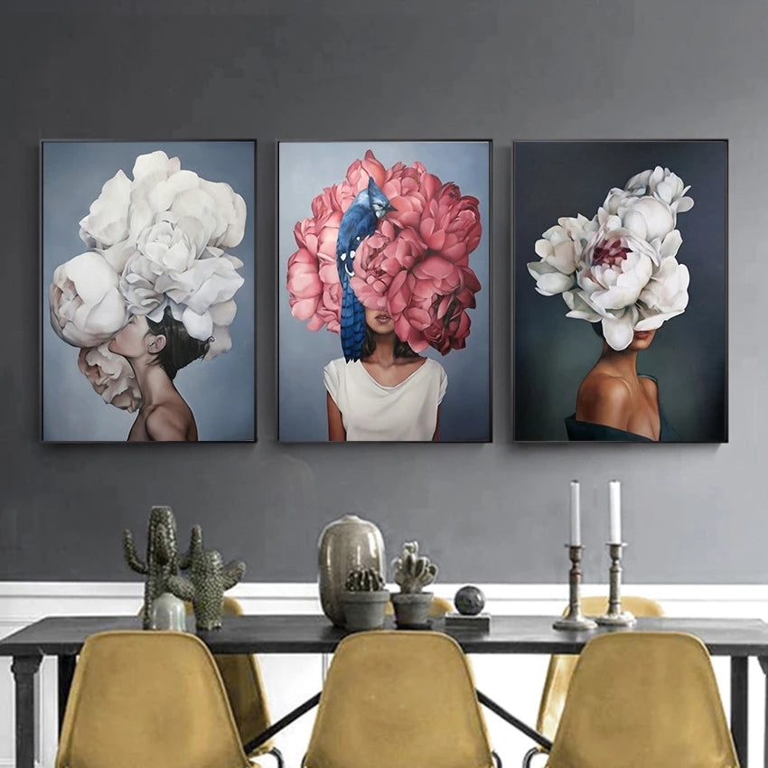 Three artistic portraits of women with floral headpieces on a wall above a dining table.